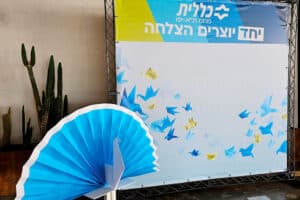 אלמנט אוריגמי עיצובי ענק, טווס אוריגמי, כנס מחוז תל אביב כללית, עיצוב בהתאמה אישית, עיצוב ממותג, אוריגמי לאירועים, הפקות לאירועי חברה, מורן אלחלל אוריגמי 