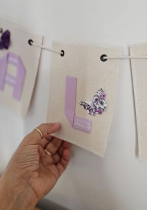 אותיות אוריגמי מעוצבות, ארבע אותיות באנגלית, אותיות בד על דגלוני קנווס, אותיות בגוון סגול בהיר, שמות מעוצבות, שרשרת אותיות לתלייה, מתנת לידה, מורן אלחלל אוריגמי בד