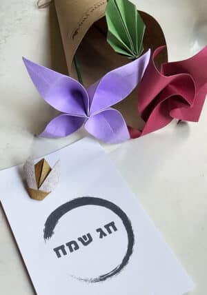 מארז שנה טובה מתנה אישית ומקורית, זוג פרחי אוריגמי באריזת קראפט מקופלים בעבודת יד, ומשלובים כרטיס ברכה חג שמח או שנה טובה עם סיכת דש , סיכה לבגד בעיצוב דבורת אוריגמי בבד זהב. מורן אלחלל מתנות מרגשות בשפת האוריגמי, מתנות בכנסים, מתנות לשנה חדשה, מתנות לעובדים, מתנות לאירועים קטנים.