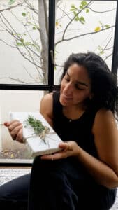 מורן אלחלל מחזיקה ספר עטוף בנייר אפייה בשיטת האוריגמי , תוצר של סדנת אוריגמי אריזות בסטייל לחגים בזום. סדנאות גיבוש לצוות, סדנאות לנשים, סדנאות יצירה מעשירות. moran alhalel holding a book packging in origami styling